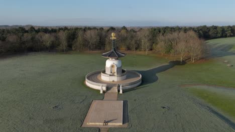 An-aerial-view-of-the-Peace-Pagoda-at-Willen-Lake-in-Milton-Keynes,-on-a-cold-winter-morning-with-the-sun-shining