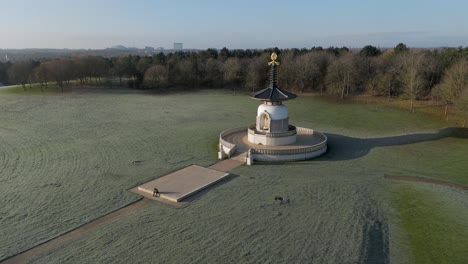 An-aerial-view-of-the-Peace-Pagoda-at-Willen-Lake-in-Milton-Keynes,-on-a-cold-winter-morning-with-the-sun-shining