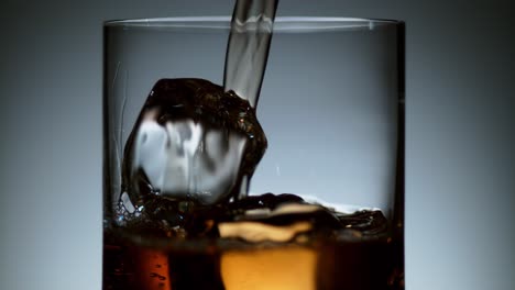 Liquor-Stream-Flowing-into-Glass-with-Ice-Cubes