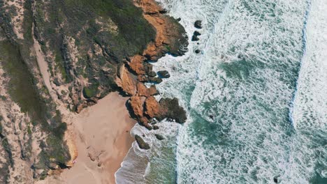 California-Big-Sur-sandy-beach-slow-motion-at-Highway-One,-famous-road-trip-route-bird-view-aerial