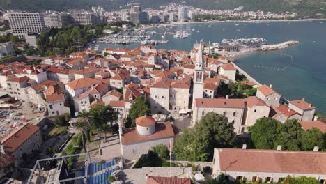 Aerial-orbiting-shot-of-Old-Budva-town-with-Marina-and-coastline-as-Background,-Montenegro