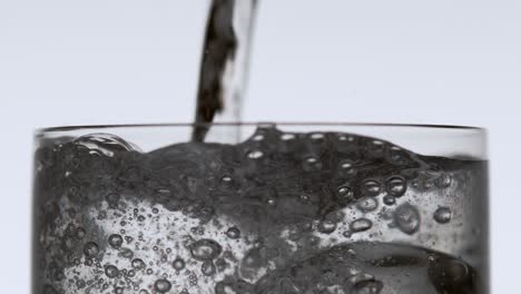 Wasser-Wird-über-Eis-In-Ein-Hohes-Trinkglas-Gegossen