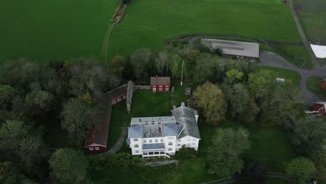 Riendas-Kloster-Rodeado-De-Campos-Verdes-Y-Vegetación-En-Rissa,-Noruega---Toma-Aérea