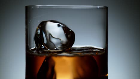 Liquor-Being-Poured-Over-Ice-Cubes-in-a-Transparent-Glass