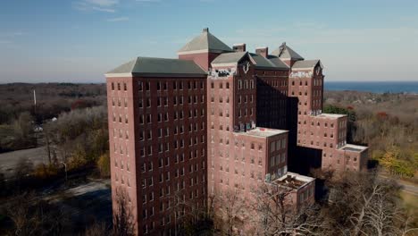 An-aerial-view-of-the-abandoned-Kings-Park-Psychiatric-Center-on-a-sunny-day-on-Long-Island,-New-York
