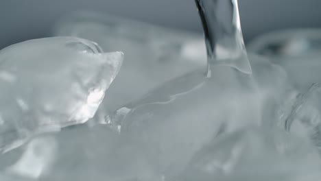 Stream-of-Water-Pouring-on-Ice-Cubes-Close-Up
