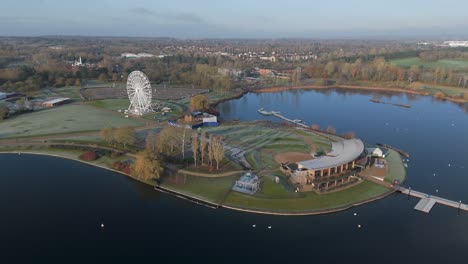 An-aerial,-early-morning-view-of-Willen-Lake-in-Milton-Keynes,-showing-the-waterfront-and-Observation-Wheel
