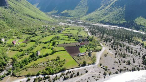 Drone-view-in-Albania-in-the-alps-vertical-panning-of-green-valley-surrounded-by-mountains-in-Theth