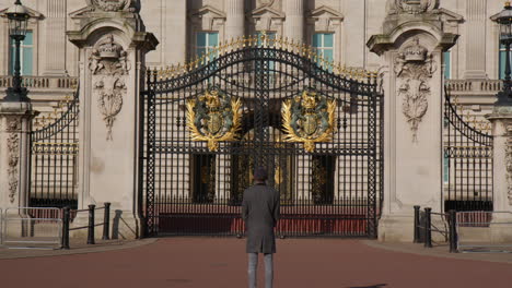 Man-Admiring-Buckingham-Palace-Gate-In-London,-United-Kingdom