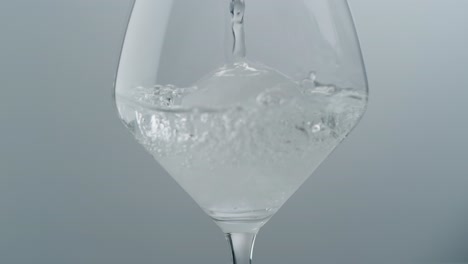 Kristallklare-Flüssigkeit,-Die-über-Eine-Eiskugel-Im-Weinglas-Gießt