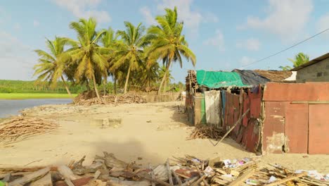 established-shot-of-Moree-ghana-africa-traditional-fisherman-village-with-ocean-sea-beach-and-palm-tree