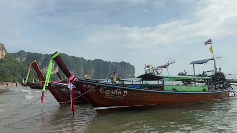 Coloridos-Barcos-De-Cola-Larga-Se-Balancean-Suavemente-Cerca-De-Una-Playa-En-Krabi,-Tailandia