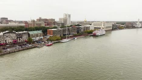 Drone-of-Savannah-Georgia-riverfront-area-along-the-river-lowering-down-to-water