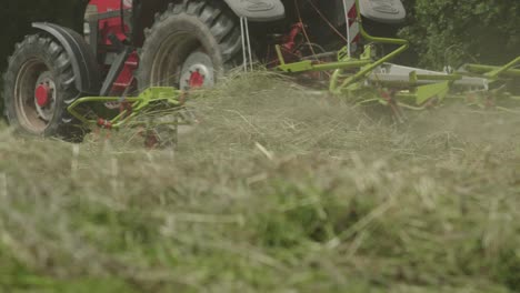 Low-angle-of-tractor-mowing-grass-in-property-field
