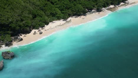 Milky-white-and-blue-water-on-the-coast-of-Bali-on-hot-summers-day,-aerial