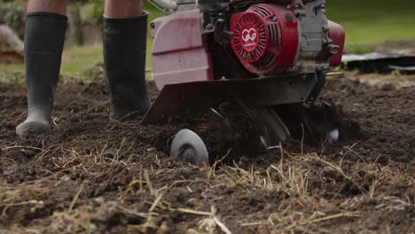Person-making-a-hole-in-the-ground-with-the-blades-of-a-machine-in-slow-motion