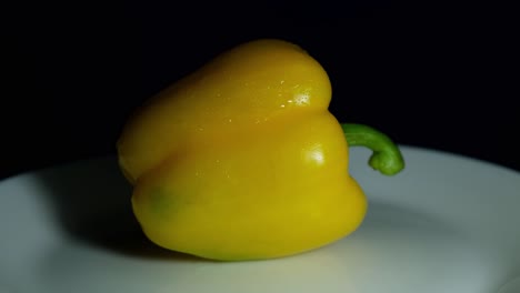 Turning-around-displayed-on-a-plate-revealing-the-freshness-of-this-vegetable-ready-to-be-cooked-or-added-in-a-salad,-Yellow-Bellpepper