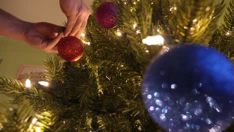 Person-Schmückt-Einen-Weihnachtsbaum-Mit-Hübschen-Funkelnden-Ornamenten