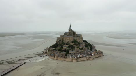 mont-saint-Michel-where-there-is-a-road,-where-many-tourists-are-walking-towards-the-castle