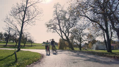 Cyclist-couple-giving-high-five-while-riding-in-the-countryside,-wide-shot