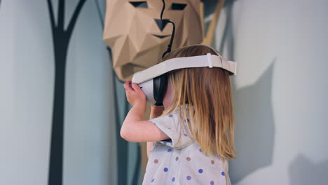 Toddler-girl-with-virtual-reality-glasses-in-a-museum-playroom,-low-angle-shot