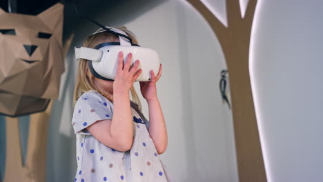Toddler-girl-with-a-virtual-reality-headset-in-a-museum-playroom,-low-angle