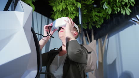 Frau-Mit-Einem-Virtual-Reality-Headset,-Die-Spaß-In-Einem-VR-Raum-Eines-Museums-Hat,-Niedriger-Winkel
