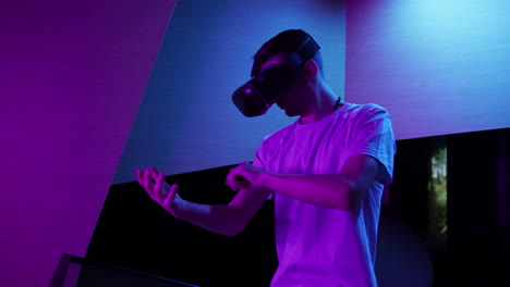 Man-with-a-VR-headset-making-various-hand-movements-in-the-air,-medium-shot