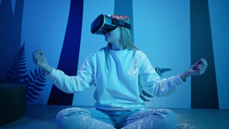 Girl-with-a-virtual-reality-headset-sitting-in-a-meditating-pose,-front-view