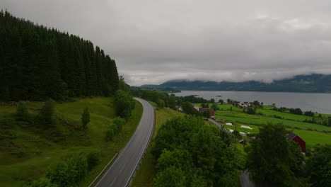 Road-Mountain-And-Coastal-Village-Against-Overcast-In-West-Coast,-Norway