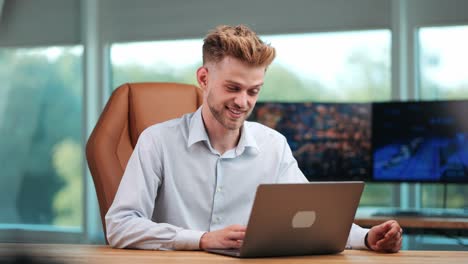 Young-Businessman-Engaged-in-Video-Call-on-Notebook-in-modern-office