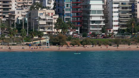 Tight-aerial-circling-shot-of-swimmers-and-water-sports-in-Athens-promenade