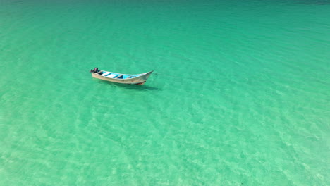 Barco-Flotando-En-Las-Aguas-Azul-Turquesa-De-La-Playa-De-Shoab-En-La-Isla-De-Socotra,-Yemen