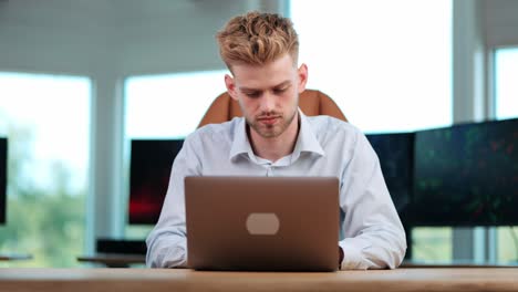 Modern-Office-Focus:-Young-Businessman-Alone,-Deep-in-Concentration-with-Notebook-Tasks