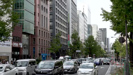 Traffic-jam-along-Midosuji-street-with-big-city-buildings-and-road-full-of-cars-in-osaka,-cityscape-view