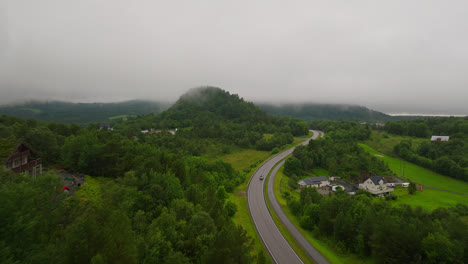 Fly-Over-Highway-In-Dense-Green-Landscape-During-Rainy-Day-In-West-Coast,-Norway