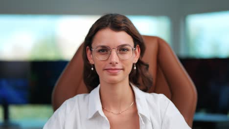 Young-Businesswoman-Looks-Directly-at-Camera-in-Modern-Office,-Close-Up-Shot-as-Camera-Approaches