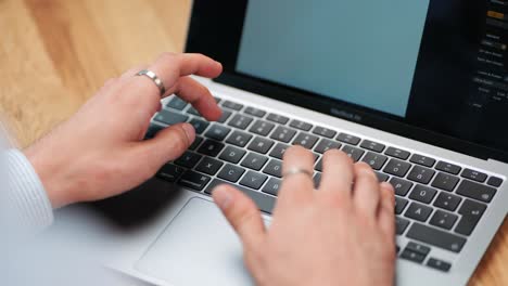 Blick-über-Die-Schulter:-Die-Hand-Eines-Mannes-Tippt-Auf-Der-MacBook-Tastatur