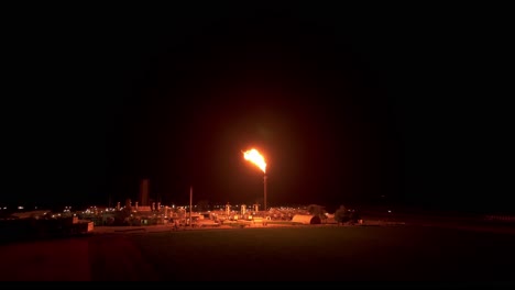 Gas-Flaring-Brightens-the-Plant-With-its-Illumination---Aerial-Pullback