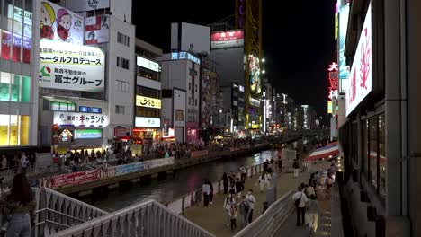 People-walking-around-busy-downtown-Dotonbori-at-night-in-Osaka,-night-time-cityscape-view