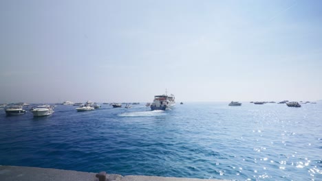 Amalfi-Positano-Italien-Immersiver-Reisetourismus-Mittelmeerküste-Wasser-Europa,-Wandern,-4k-|-Mann-Geht-Vom-Boot-Auf-Den-Pier,-Während-Die-Yachten-Abfahren,-Wackelig