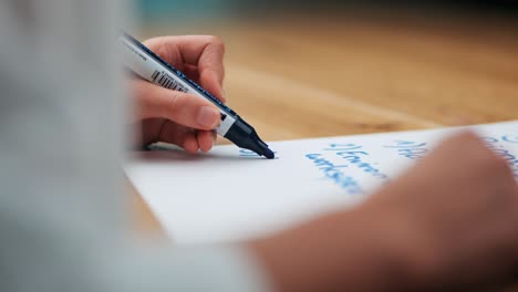 Strategic-Thinking:-Woman's-Hand-Engaged-in-Business-Brainstorming-with-Blue-Marker-on-wooden-table