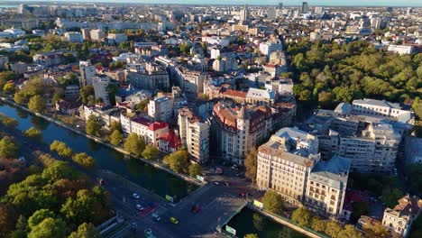 An-Aerial-View-of-Bucharest's-Izvor-District-as-the-Dambovita-River-Glistens-at-Sunset,-Romania