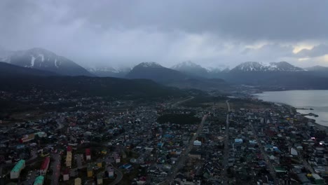 Drone-shot-flying-over-Ushuaia,-Argentina-towards-the-Andes-mountains-at-dusk