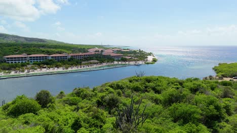 Aerial-push-in-over-dry-arid-Caribbean-landscape-to-reveal-Sandals-beach-resort-and-Santa-Barbara-beach