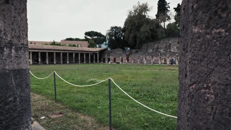 Tourists-explore-Peaceful-Gladiators'-Barracks,-ancient-Pompeii,-Italy