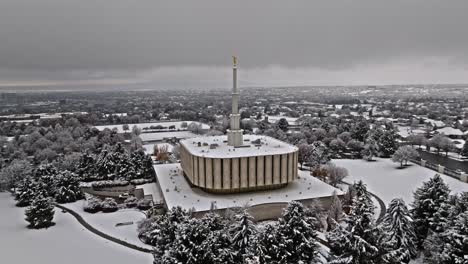 Aerial-orbit-around-Provo-LDS-Mormon-Temple-covered-in-snow-view-out-to-Utah-Lake