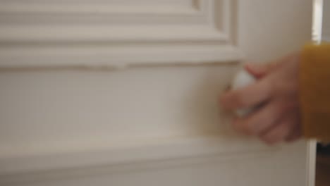 Close-up-shot-of-a-female-hands-opening-door-by-holding-handle-of-the-door-inside-a-house