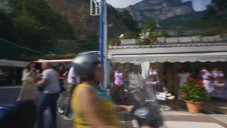 Amalfi-Positano-Italy-Immersive-Travel-Tourism-Mediterranean-Sea-Coast-Water-Europe,-Walking,-4K-|-Motorcycle-Passing-Near-Asian-Travelers-Exploring-Roads-Below-Famous-Mountainside-Cliffs,-Shaky