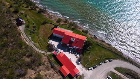 Drone-shot-descending-while-tracking-the-Hosteria-Kaiken-on-the-shores-of-Lago-Fagnano-in-Tierra-del-Fuego,-Argentina